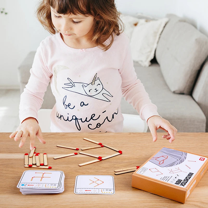 Petite fille concentrée réalisant une figure avec les allumettes
